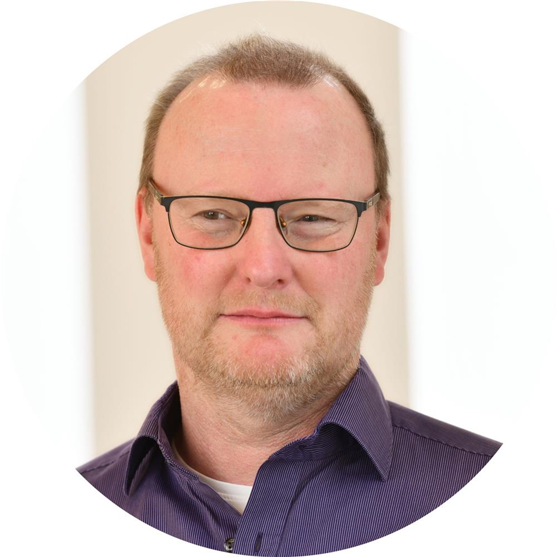 Ein Mann lächelt in die Kamera.