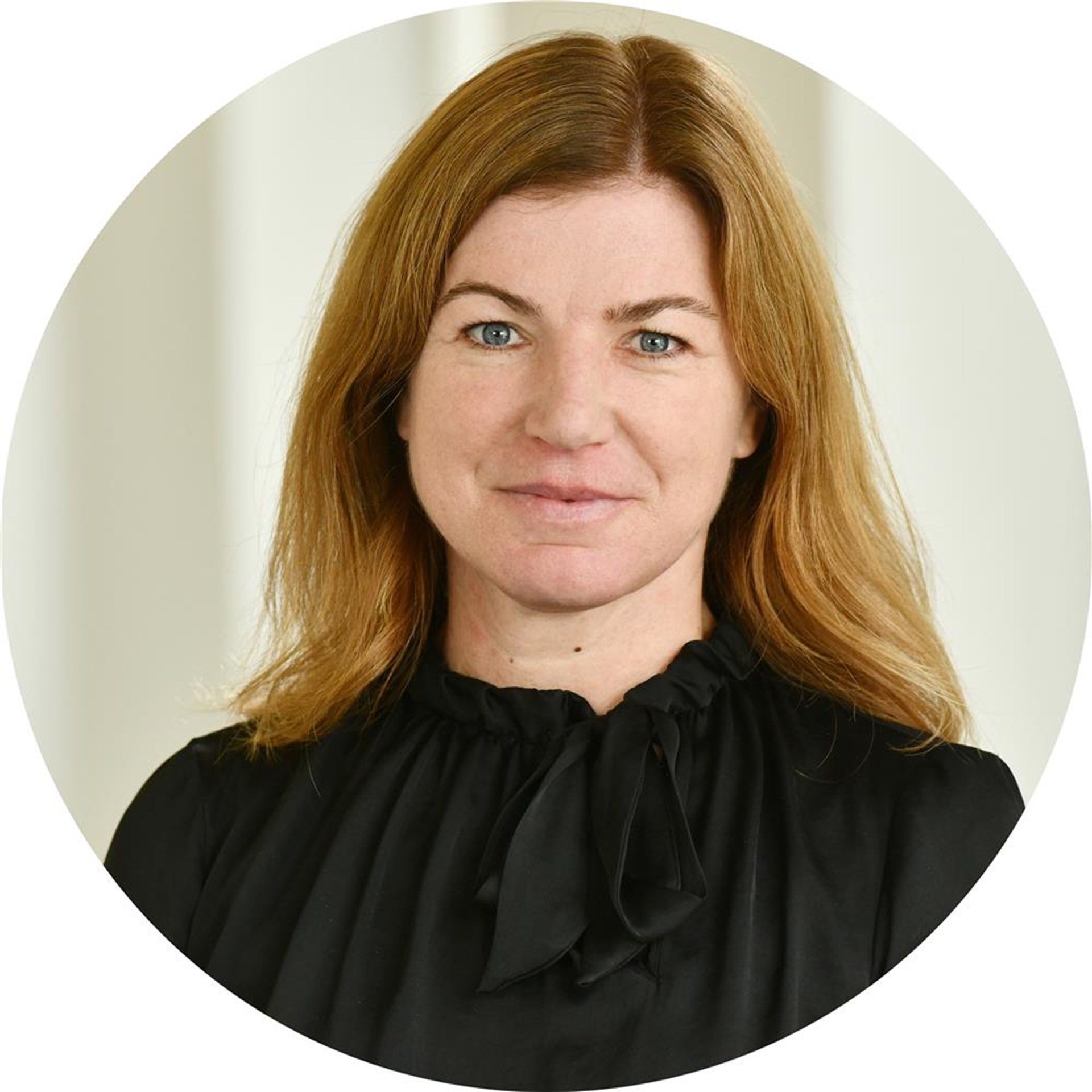 Eine Frau lächelt in die Kamera.