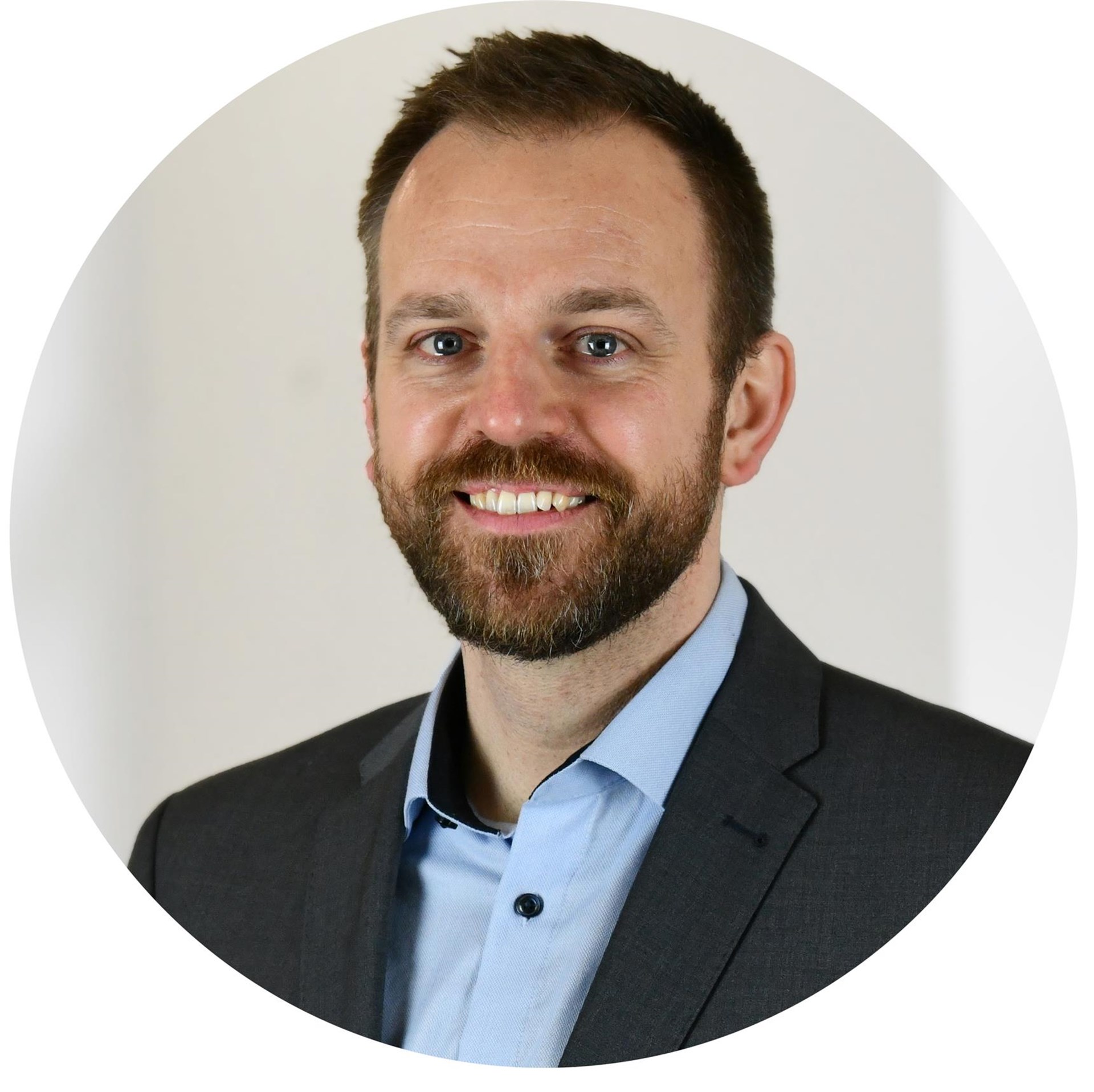 Mann mit dunklem Bart lächelt