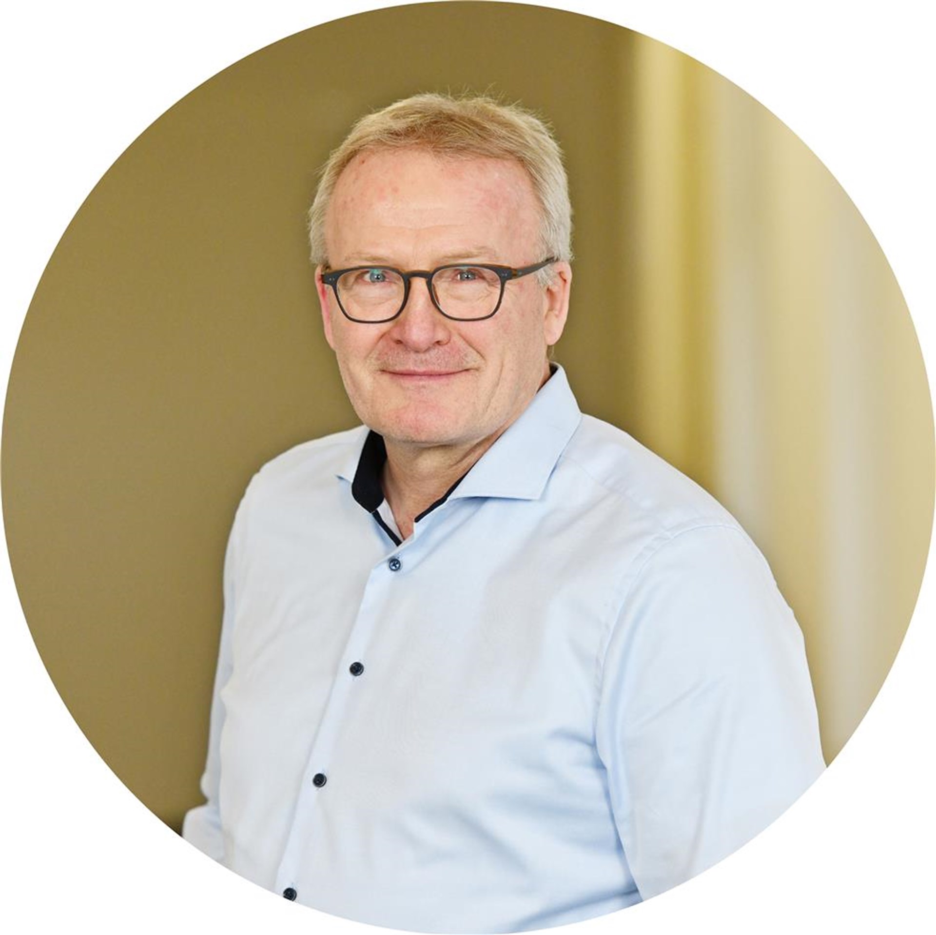 Ein Mann mit Brille lächelt in die Kamera.